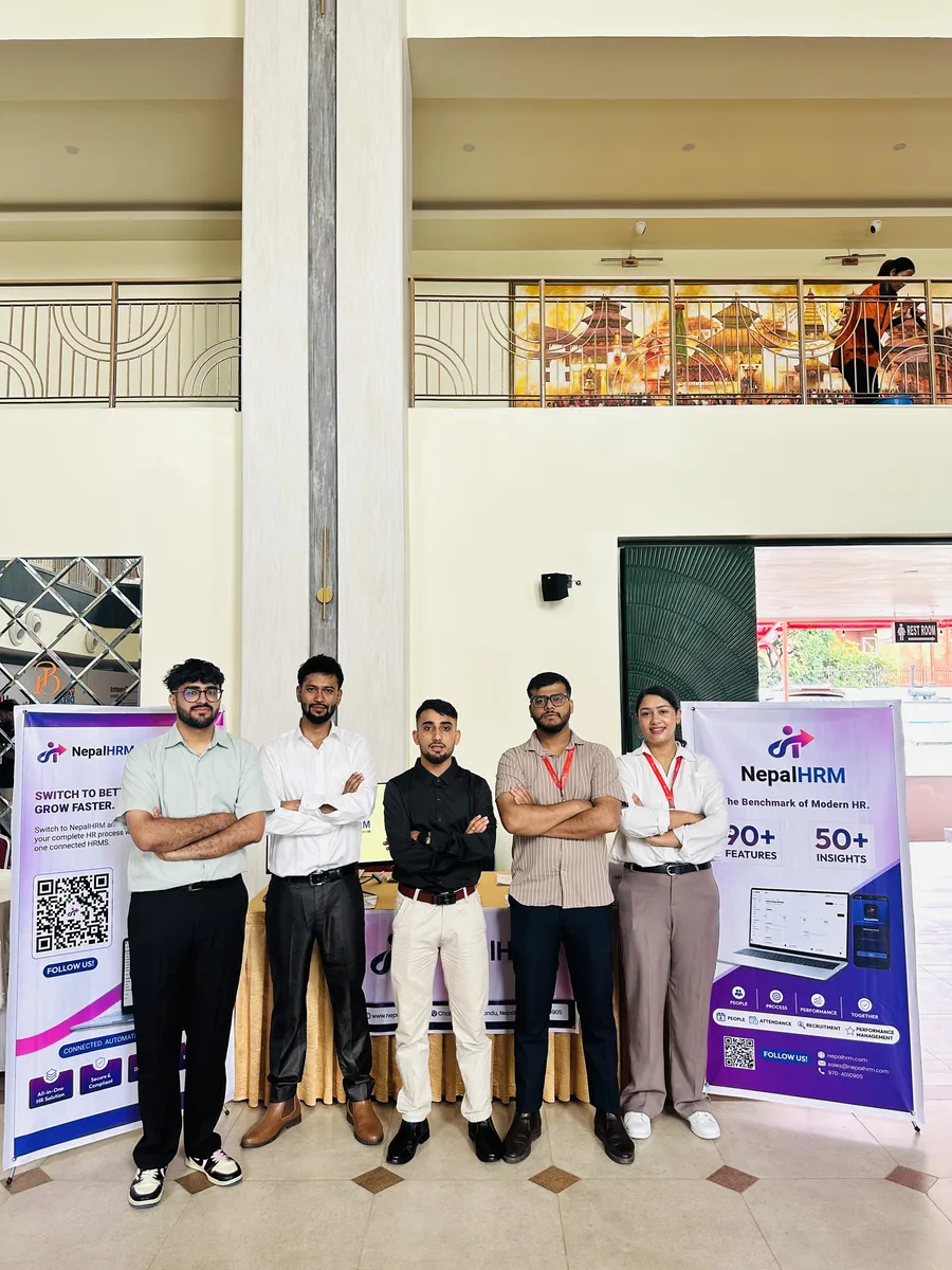 Five members of the NepalHRM team standing between two branded standees at their Idea Summit 2026 stall in Kathmandu.