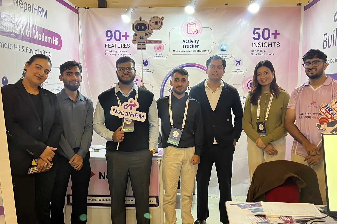 Seven people from NepalHRM lined up in front of the NepalHRM stall on the opening day of Nepal Fintech Expo 2026, one holding a NepalHRM sign