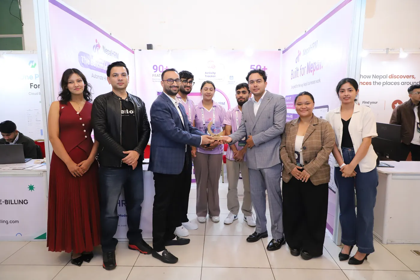 Fintech Alliance Nepal presenting a trophy to NepalHRM in front of the NepalHRM stall, with the team and guests standing either side